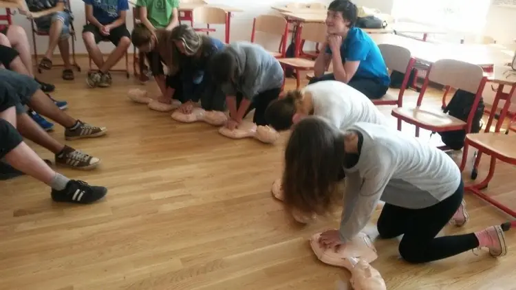Žáci nacvičují resuscitaci na figuríně na kurzu mladého zdravotníka